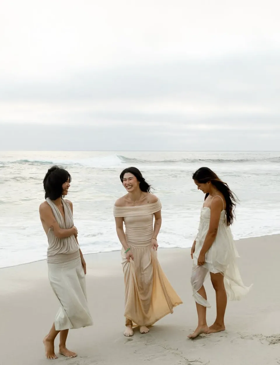 Three friends laughing at the water’s edge